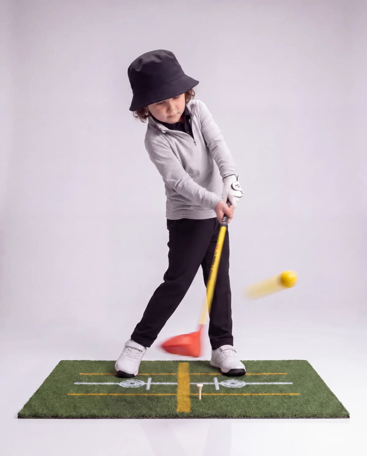 Toddler mid-swing, hands on the Lil' Legends driver grip