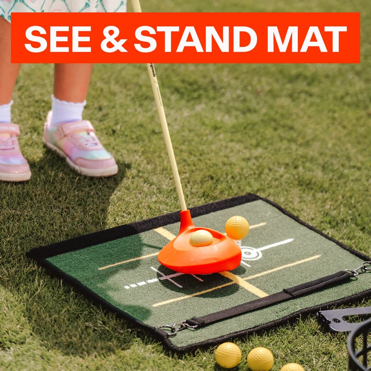A child using the Lil’ Legends driver on the See & Stand Mat, with yellow balls and visual alignment guides.