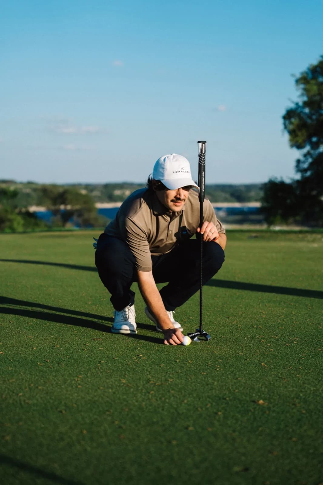 Golfer crouching to read the line with RS1 putter