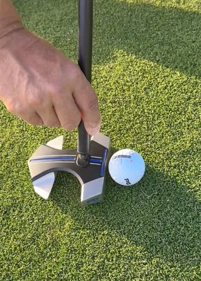 Putter set up behind an iON+ ball at golden hour