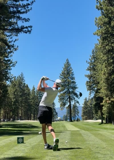 Tee shot follow-through on a tree-lined par 4