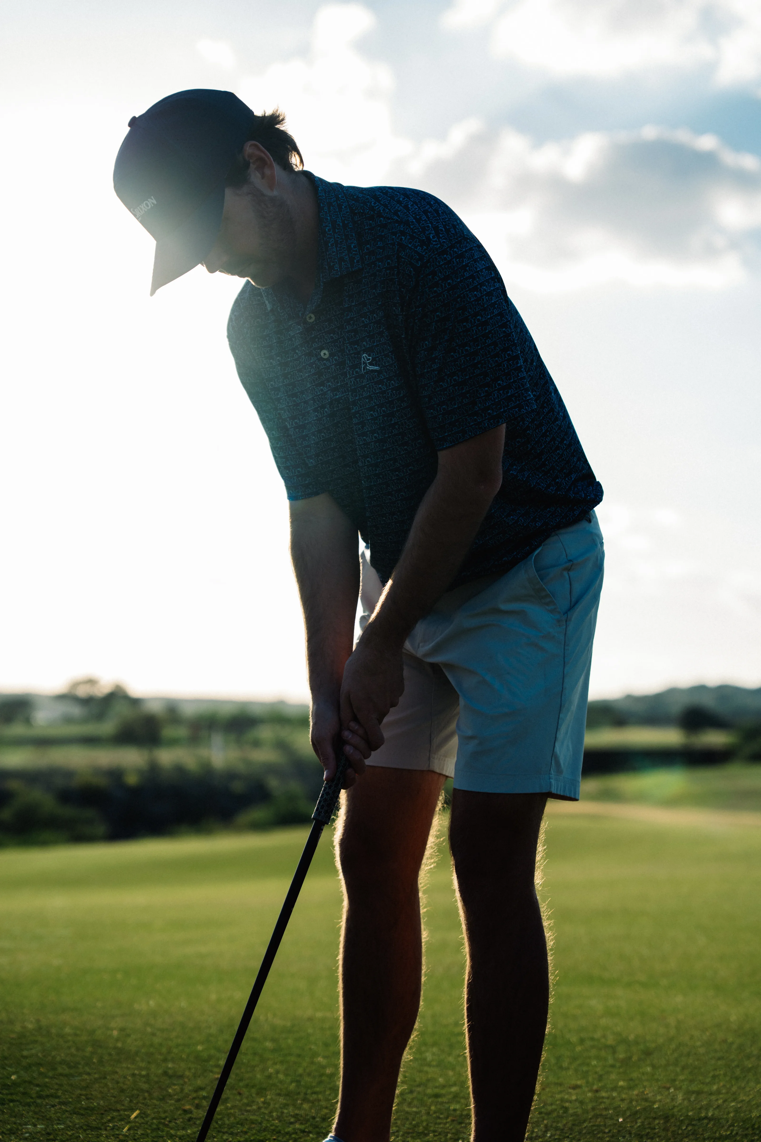 Golfer putting with RS1 at sunset