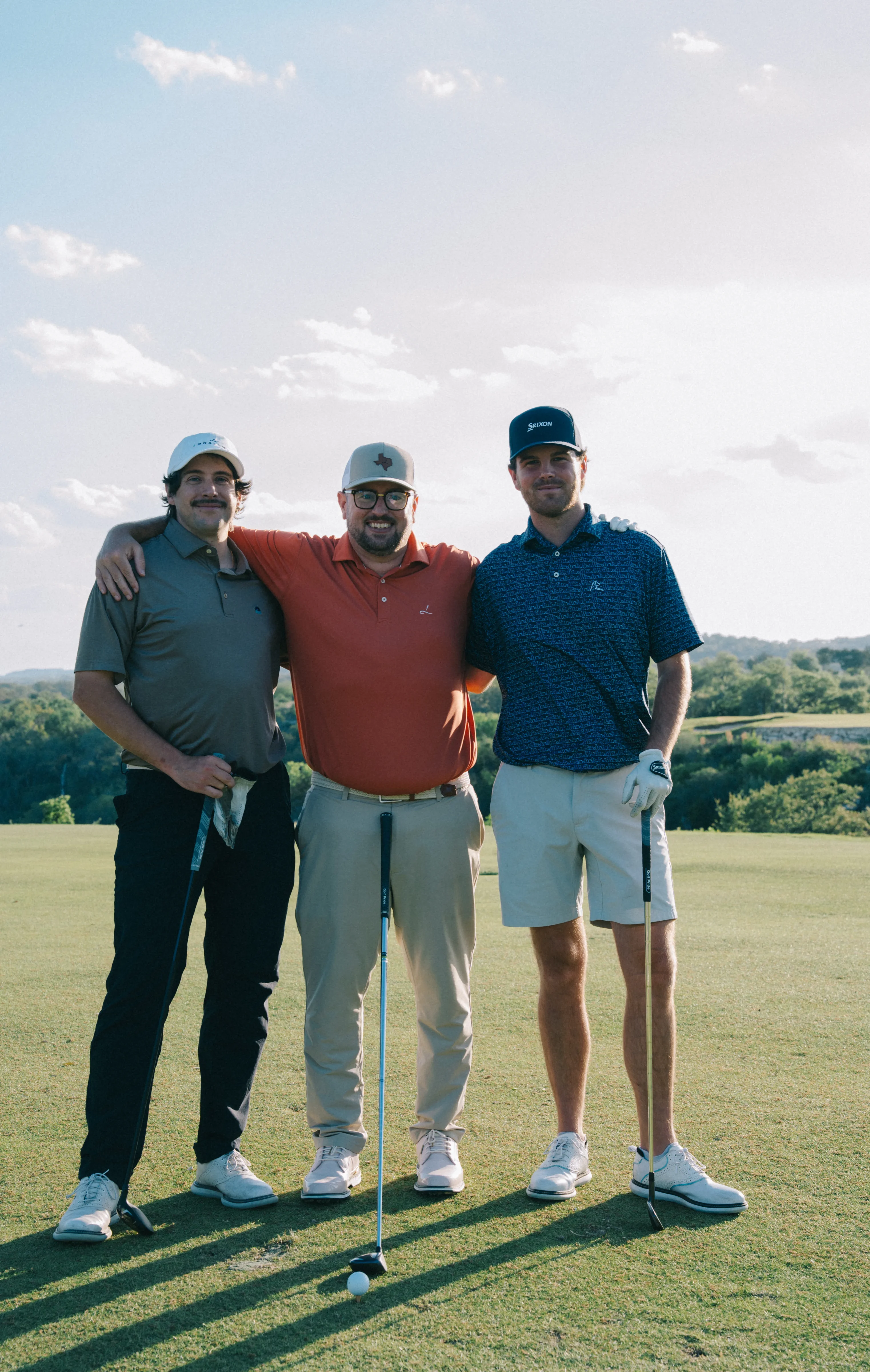 Three golfers posing on the course