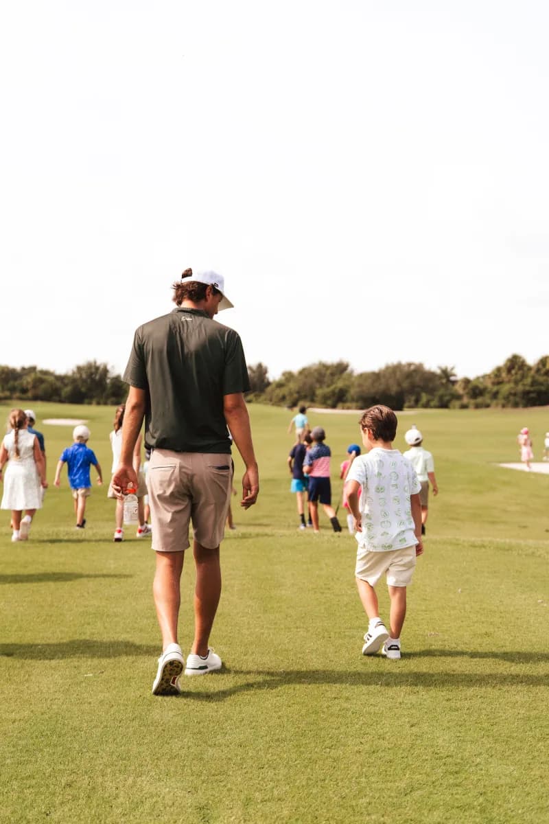 Parent and toddler walking the fairway together